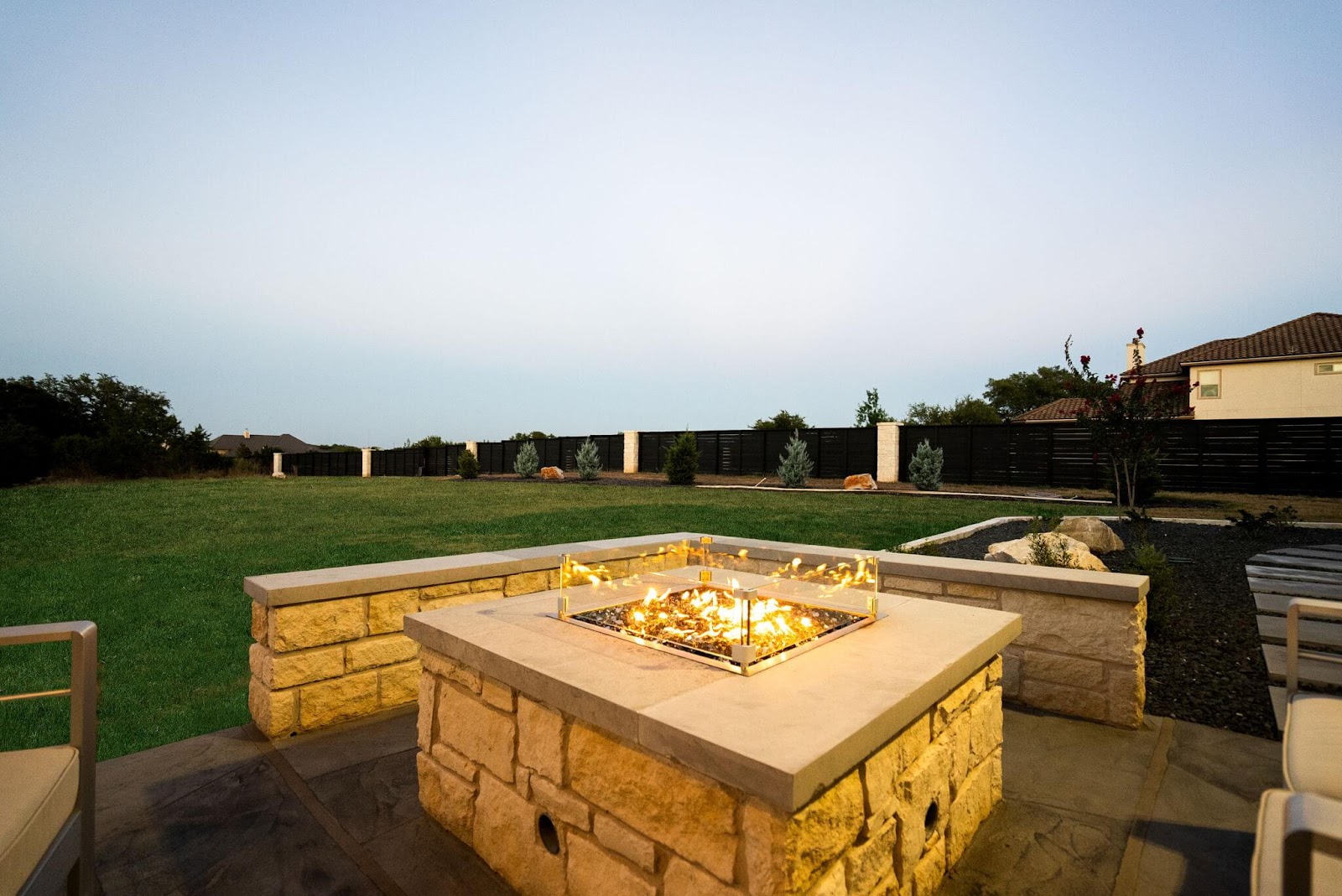 custom fire pit table with natural stone and concrete materials, texas backyard
