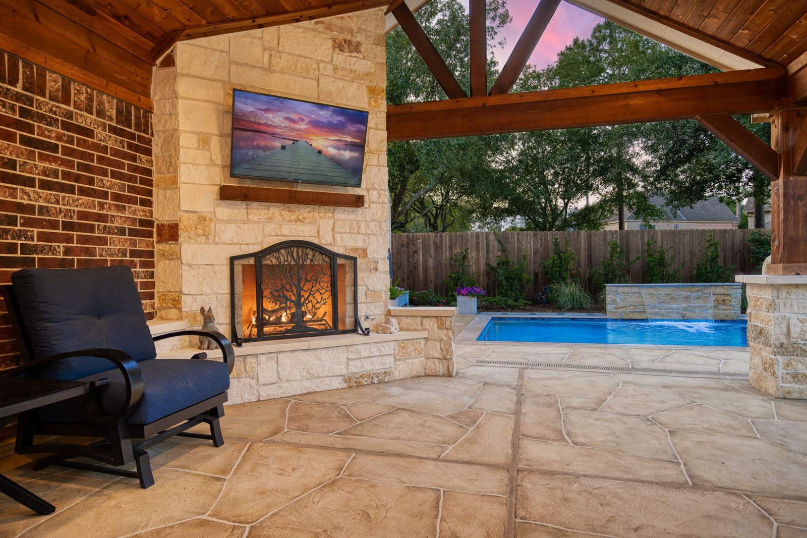 outdoor fireplace with hearth and mantle, stacked stone design on gable covered patio
