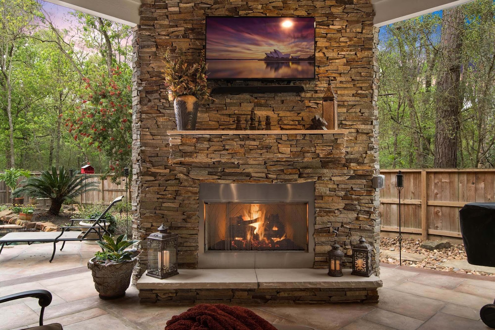 rustic stone outdoor fireplace with custom mantle on covered patio, texas