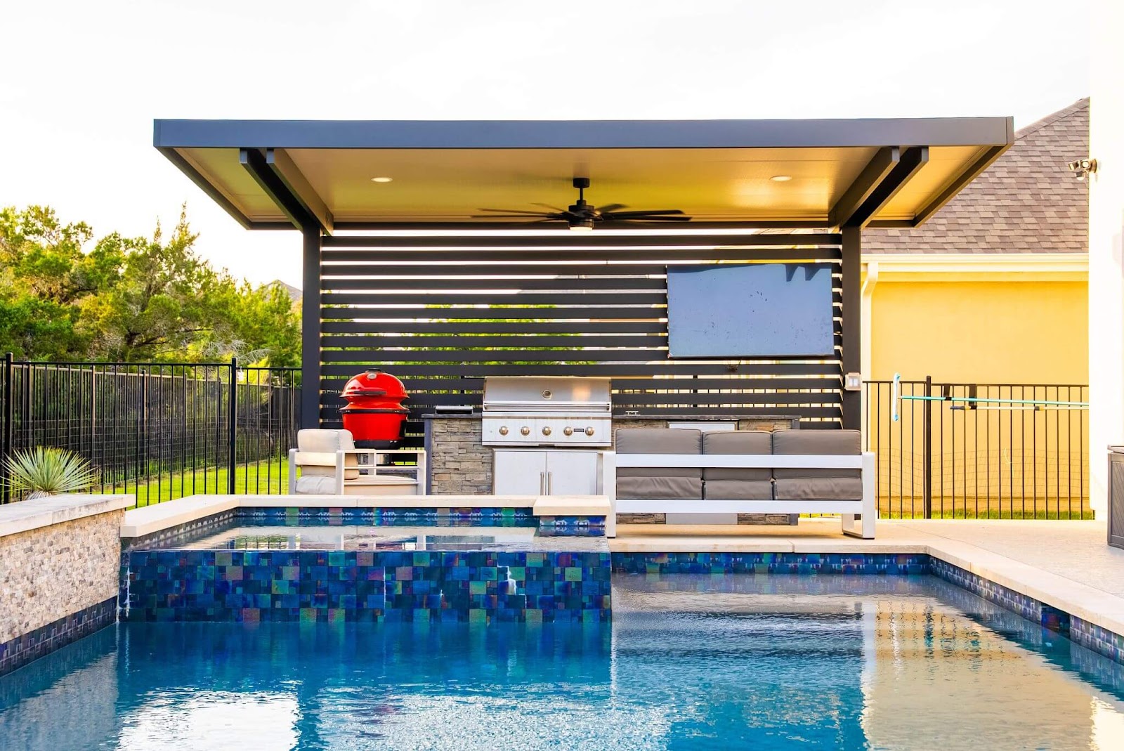 poolside covered patio space with grill island, stainless steel grill