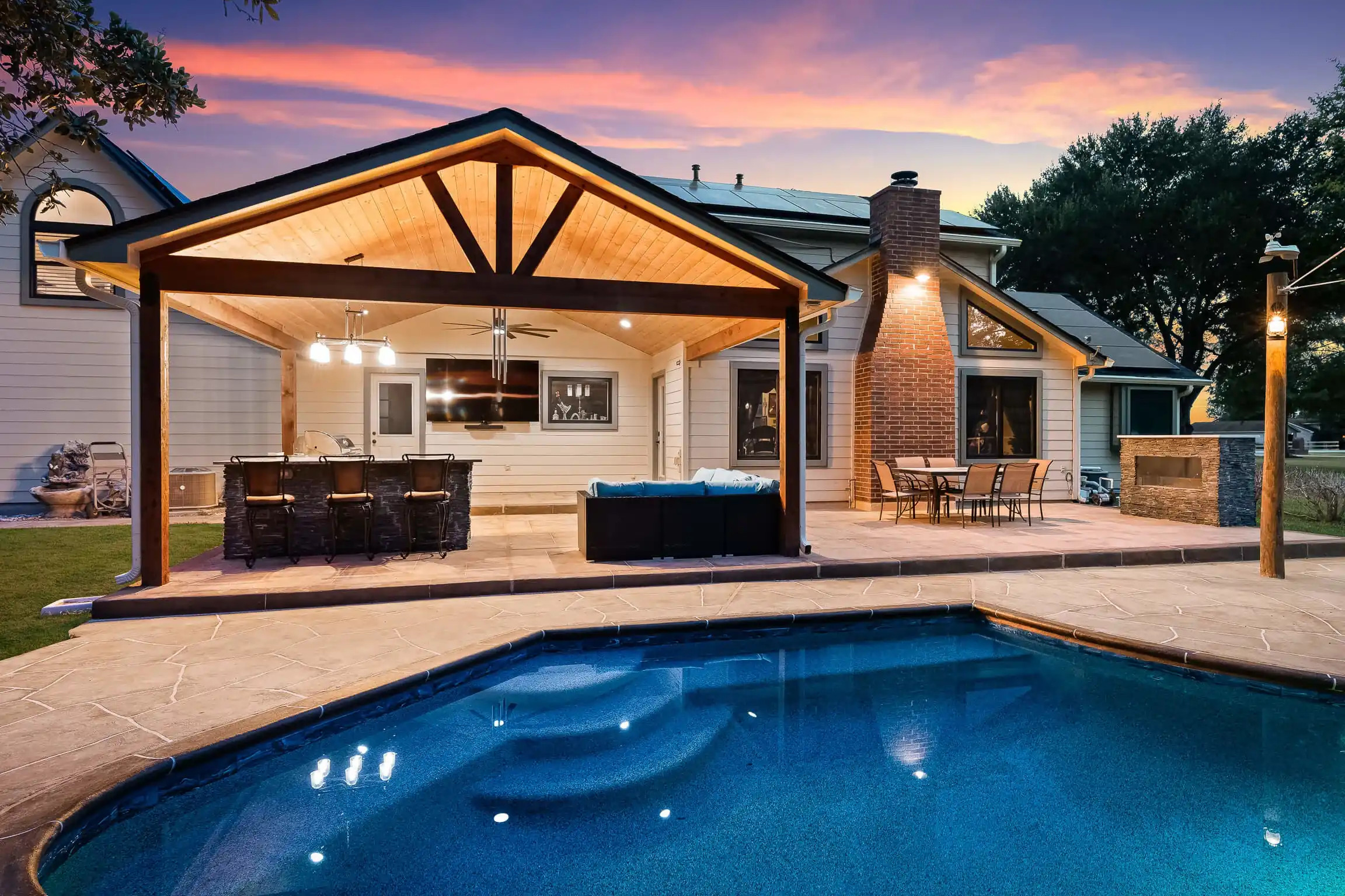 gable style patio roof, outdoor backyard bar and grill next to inground pool