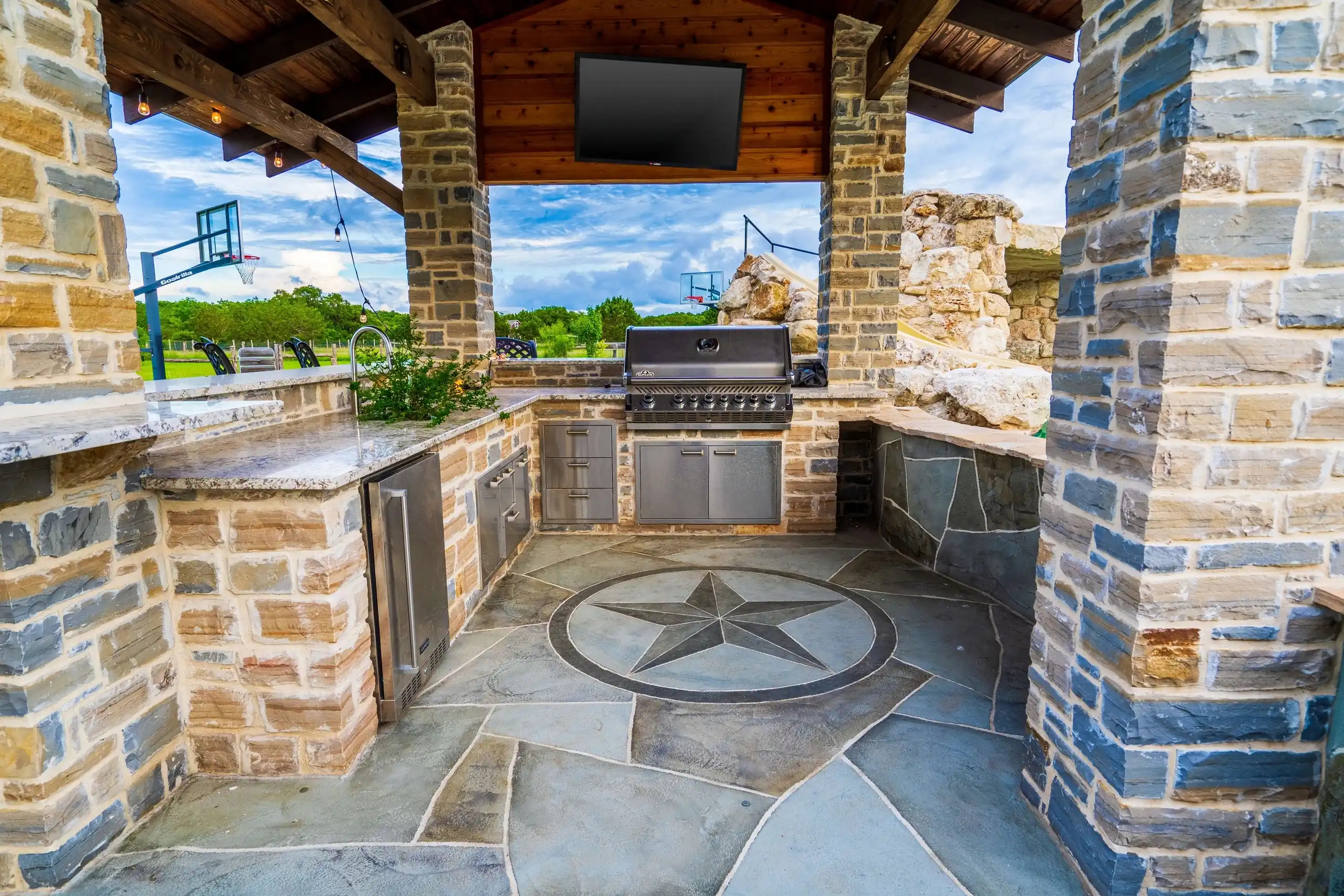 rustic brick outdoor grill station with grill island countertops and shade structure