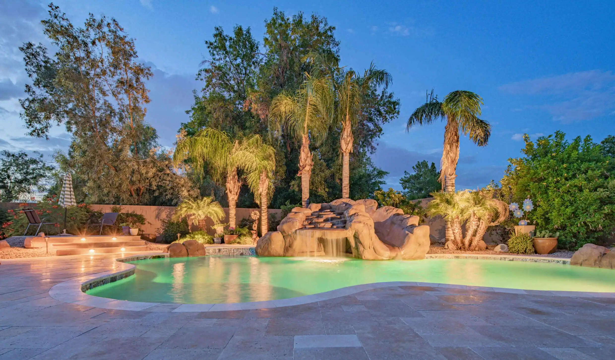 rock waterfall as statement hardscaping feature on pool deck in texas