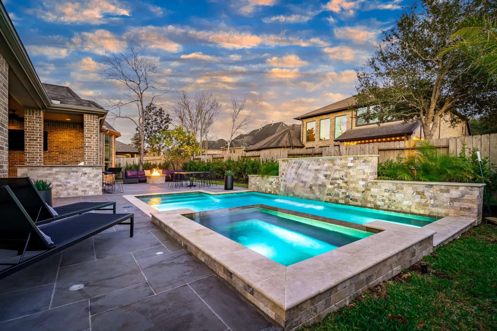 texas backyard oasis with inground pool and spa, natural stone wall and water feature