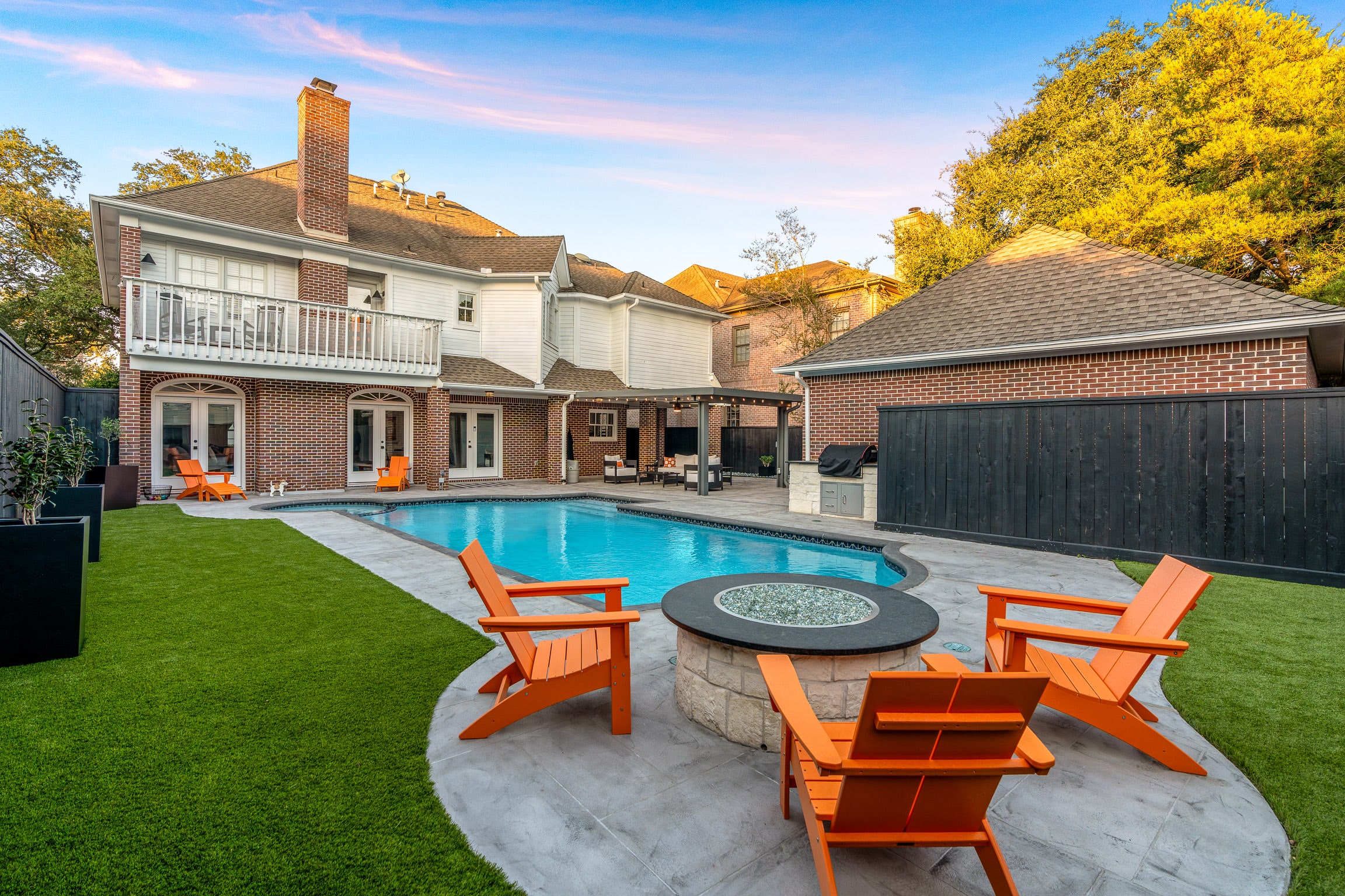 Artificial turf putting green beside luxury backyard patio area